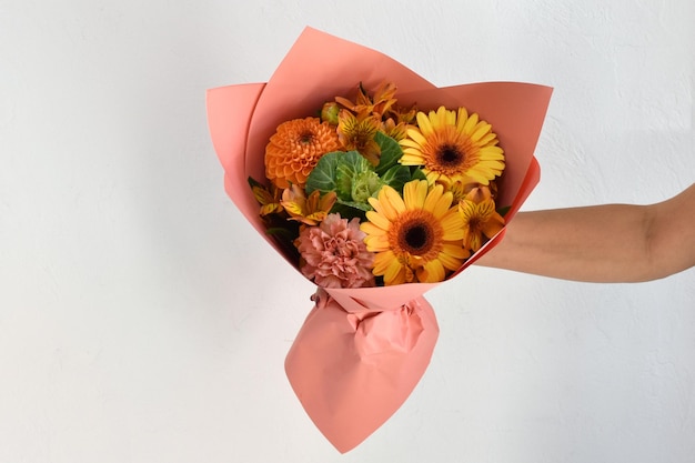 Hermosas flores para vacaciones Mujer con hermosas flores en las manos en el interior de fondo ramo de flores para floristería