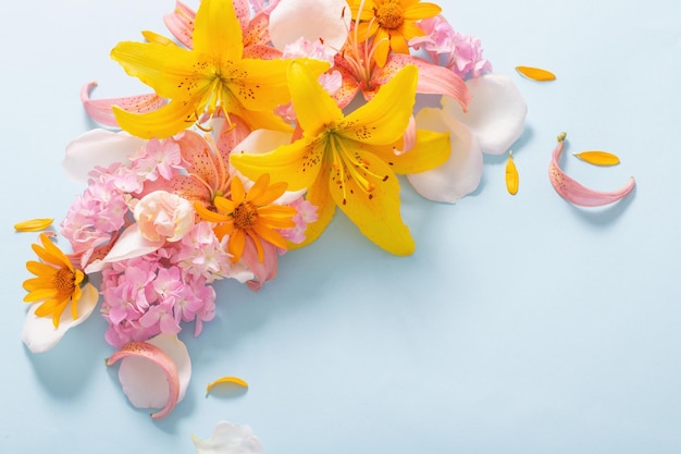 Hermosas flores de verano sobre fondo de papel azul