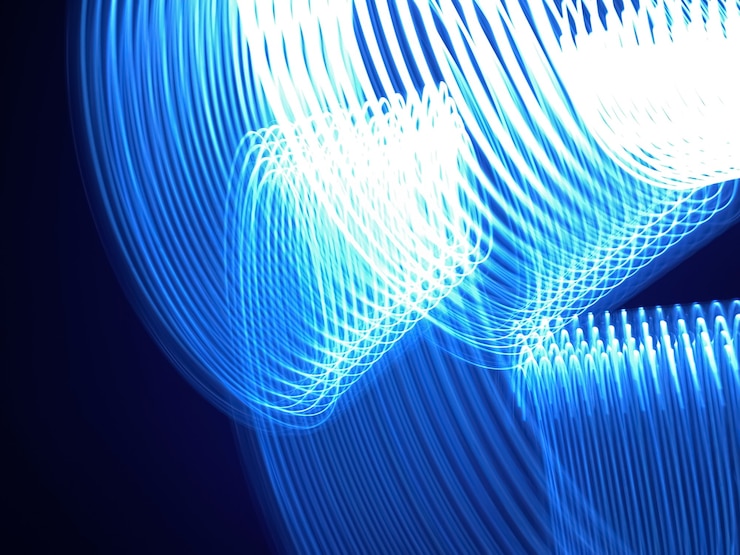Foto hermosas formas gráficas hechas de luz con una larga exposición. patrón de fondo en tonos de color azul clásico del año 2020.