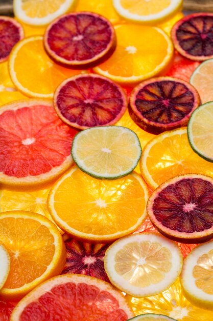 Hermosas frutas cítricas mezcladas en rodajas frescas como fondo, concepto de alimentación saludable, dieta, vista superior