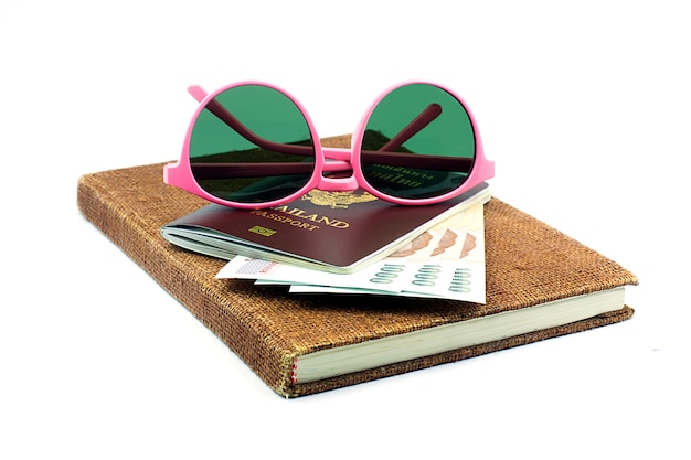 Foto hermosas gafas de color rosa y el pasaporte de tailandia con efectivo tailandés en el cuaderno marrón