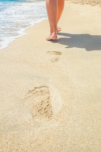 Hermosas huellas con pies cerca del mar.