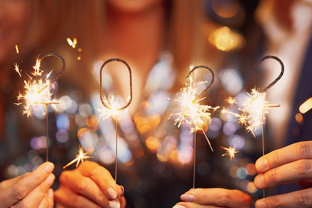 Hermosas jóvenes amigas divirtiéndose en la fiesta de fin de año con números 2022