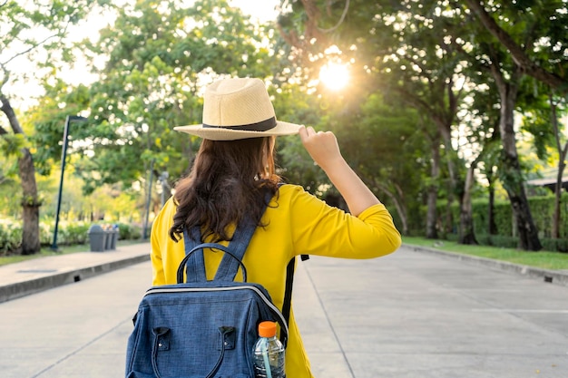 Hermosas jóvenes turistas asiáticas camisas amarillas sombreros de paja mochilas Viajando en un parque en Tailandia Tiene mucha pasión y felicidad
