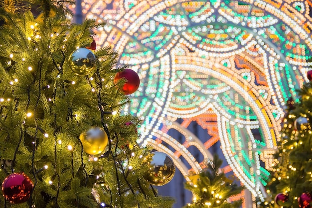 Hermosas luces navideñas borrosas en abetos decorados por la noche