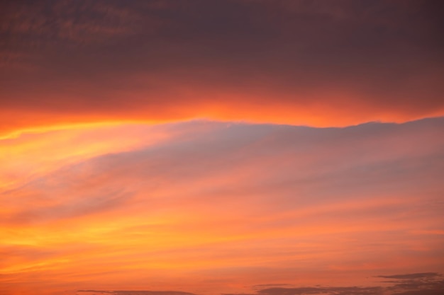 Hermosas y lujosas nubes de color naranja dorado con gradiente suave y luz solar en el cielo azul, perfectas para el fondo en el crepúsculo, foto de paisaje de gran tamaño y alta definición