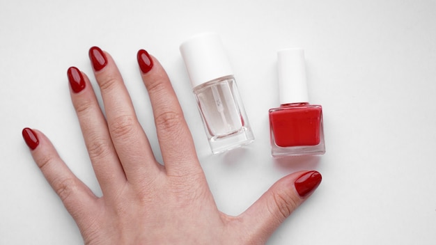 Hermosas manos femeninas. Cuidado de la piel de las manos. Manos de mujer hermosa con manicura roja. Esmalte de uñas rojo y aceite para cutículas.