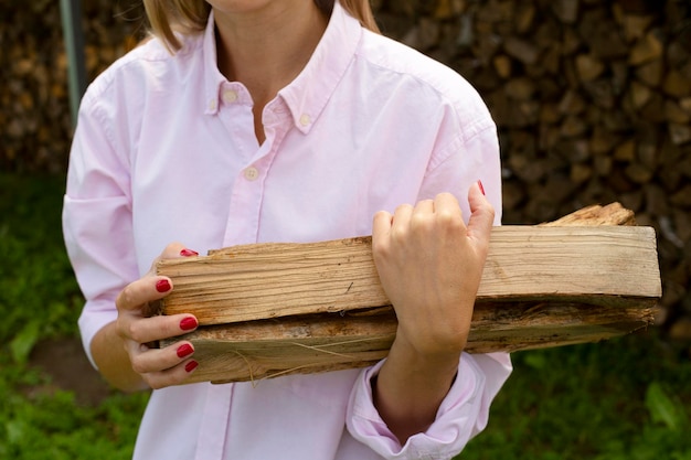 Hermosas manos femeninas sostienen leña Calentando la casa con madera