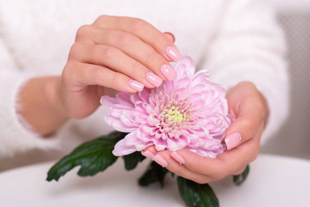 Hermosas manos femeninas con uñas de manicura de boda flor de peonía de esmalte de gel rosa