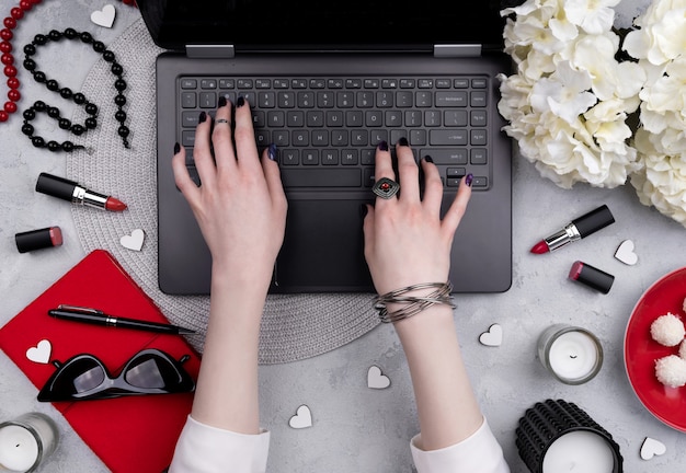 Hermosas manos de mujer arreglada escribiendo en el teclado en la mesa de la oficina en casa