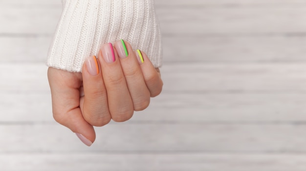 Hermosas manos de mujer arregladas con uñas de colores.