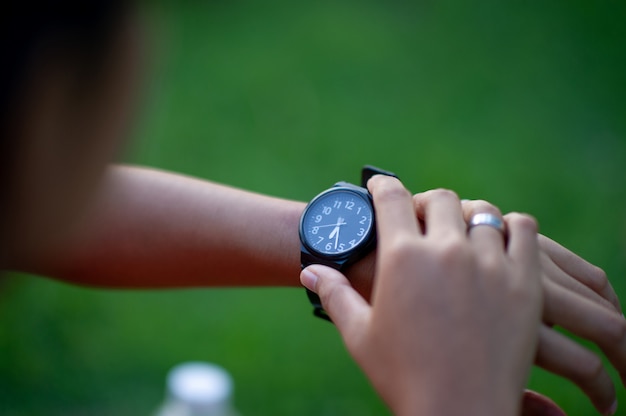 Hermosas manos negras y relojes Una verificación de tiempo para precisión y puntualidad