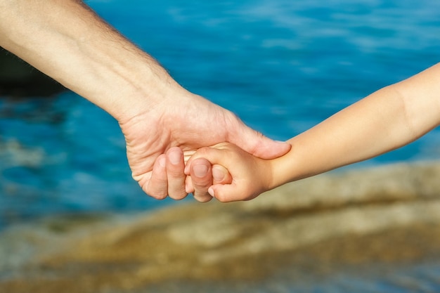 Hermosas manos de padres e hijos junto al mar