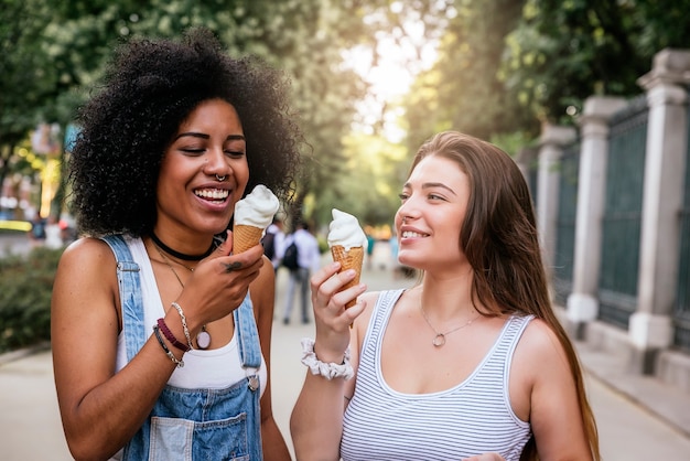Hermosas mujeres comiendo un helado en la calle. Concepto de juventud.
