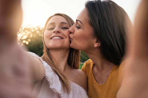 Hermosas mujeres divirtiéndose en el parque. Amigos y concepto de verano.