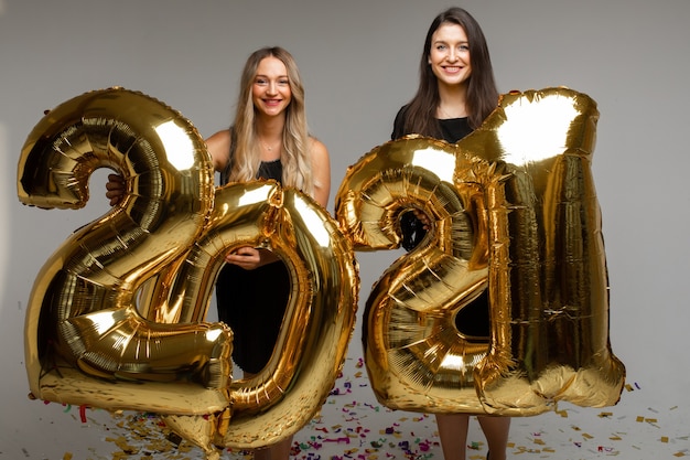 Hermosas mujeres con globos de año nuevo 2021.