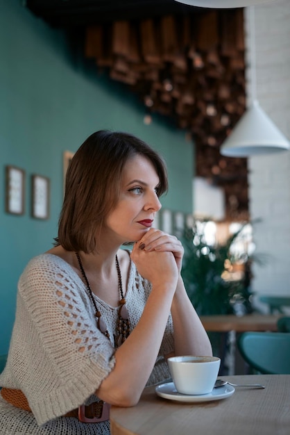 Hermosas mujeres jóvenes bebiendo té o café en el restaurante Retrato de mujer morena con mirada dura