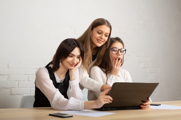 Foto hermosas mujeres jóvenes en la oficina con ordenador portátil