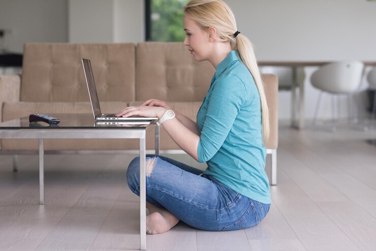 Foto hermosas mujeres jóvenes que usan una computadora portátil en el piso de su casa de lujo