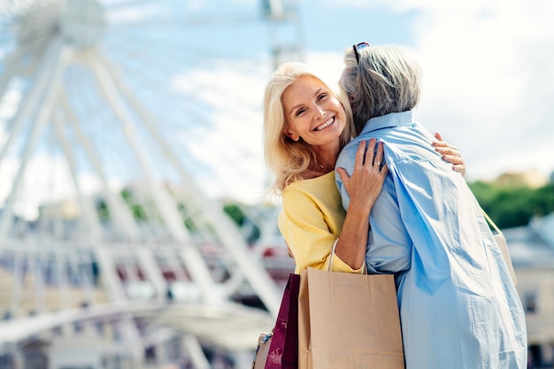 Hermosas mujeres mayores felices de compras en el centro de la ciudad