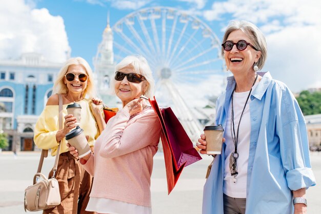 Hermosas mujeres mayores felices de compras en el centro de la ciudad