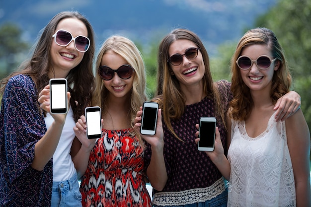 Hermosas mujeres mostrando sus teléfonos móviles
