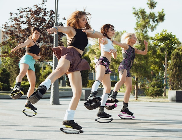 Hermosas mujeres en ropa deportiva saltando en un kangoo salta zapatos en la calle