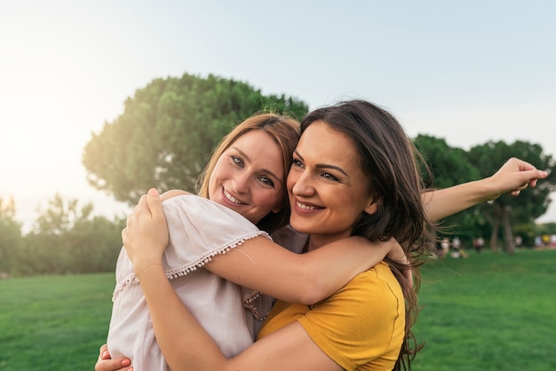 Hermosas mujeres sonriendo y divirtiéndose en el parque. Amigos y concepto de verano.