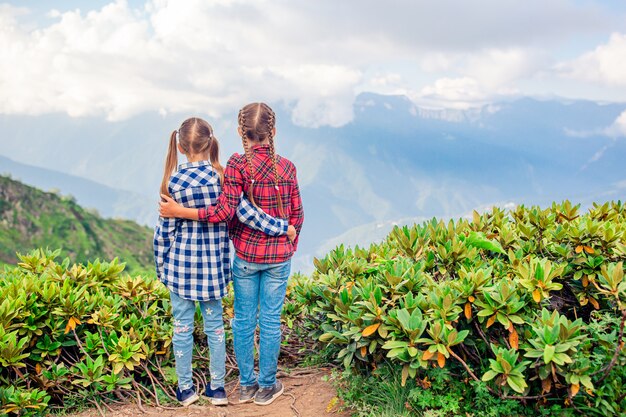 Hermosas niñas felices en las montañas en el fondo de niebla