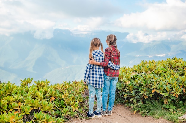 Foto hermosas niñas felices en las montañas en el fondo de niebla