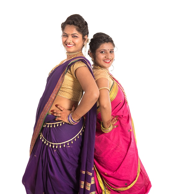 Hermosas niñas indias tradicionales en sari posando en blanco