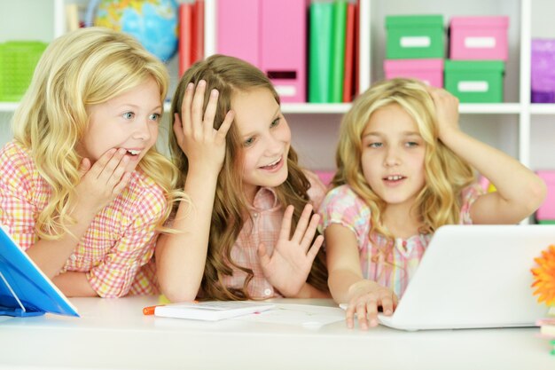 Hermosas niñas con laptop en clase