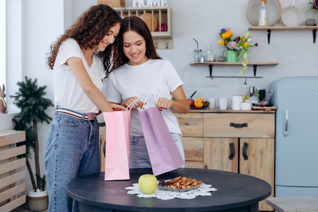 Hermosas novias chicas consideran sus compras en casa