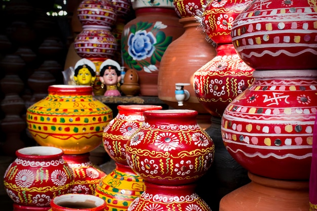 Hermosas ollas indias rojas pintadas en flores de color blanco verde y amarillo y diseños de líneas