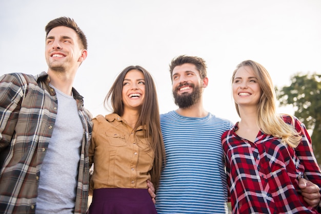 Hermosas parejas están sonriendo y caminando afuera.