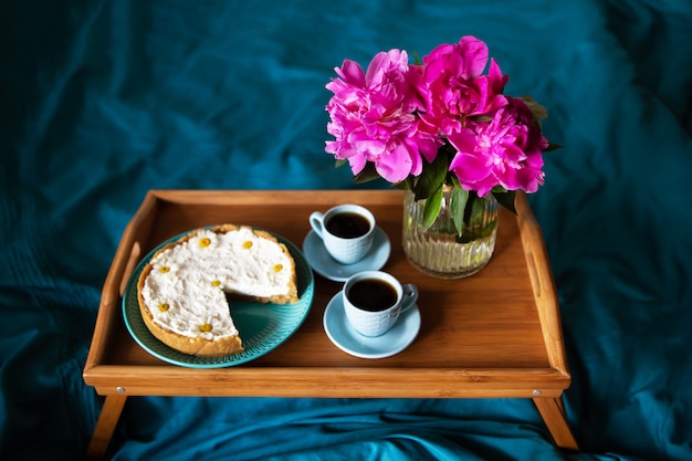 Hermosas peonías rosas y dos tazas de café y panqueques