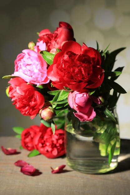 Hermosas peonías rosas en jarrón sobre fondo claro