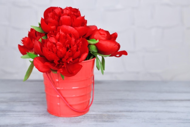 Hermosas peonías rosas sobre fondo de pared gris