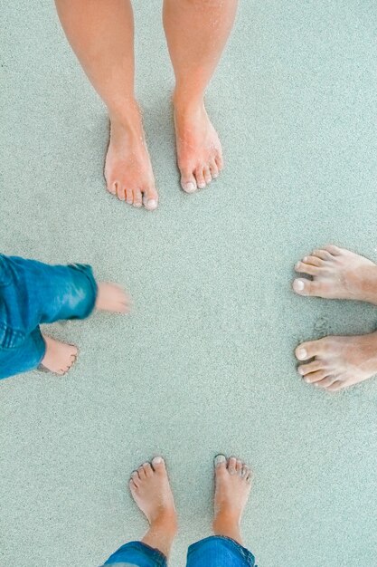 Foto hermosas piernas en la arena cerca del mar en el fondo de la naturaleza