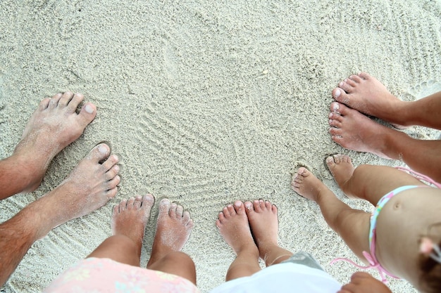 Hermosas piernas en la arena junto al mar.