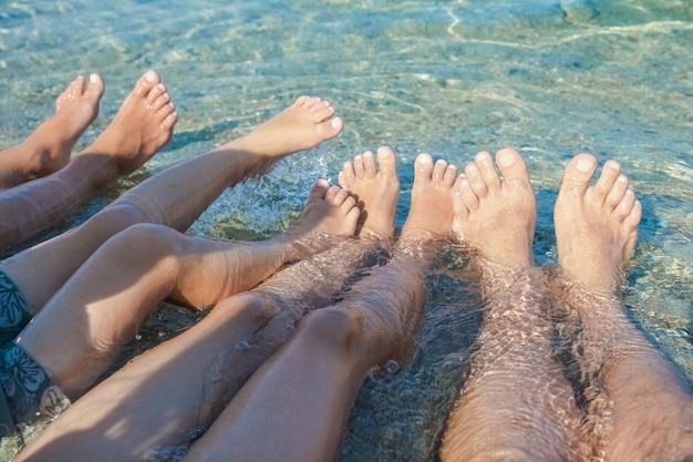 Foto hermosas piernas en la arena junto al mar