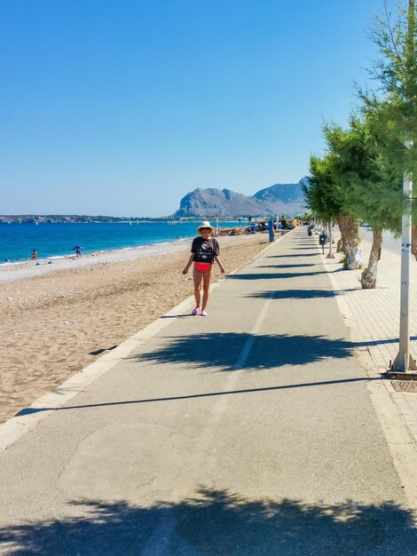 Hermosas piernas en la arena del mar de fondo grecia