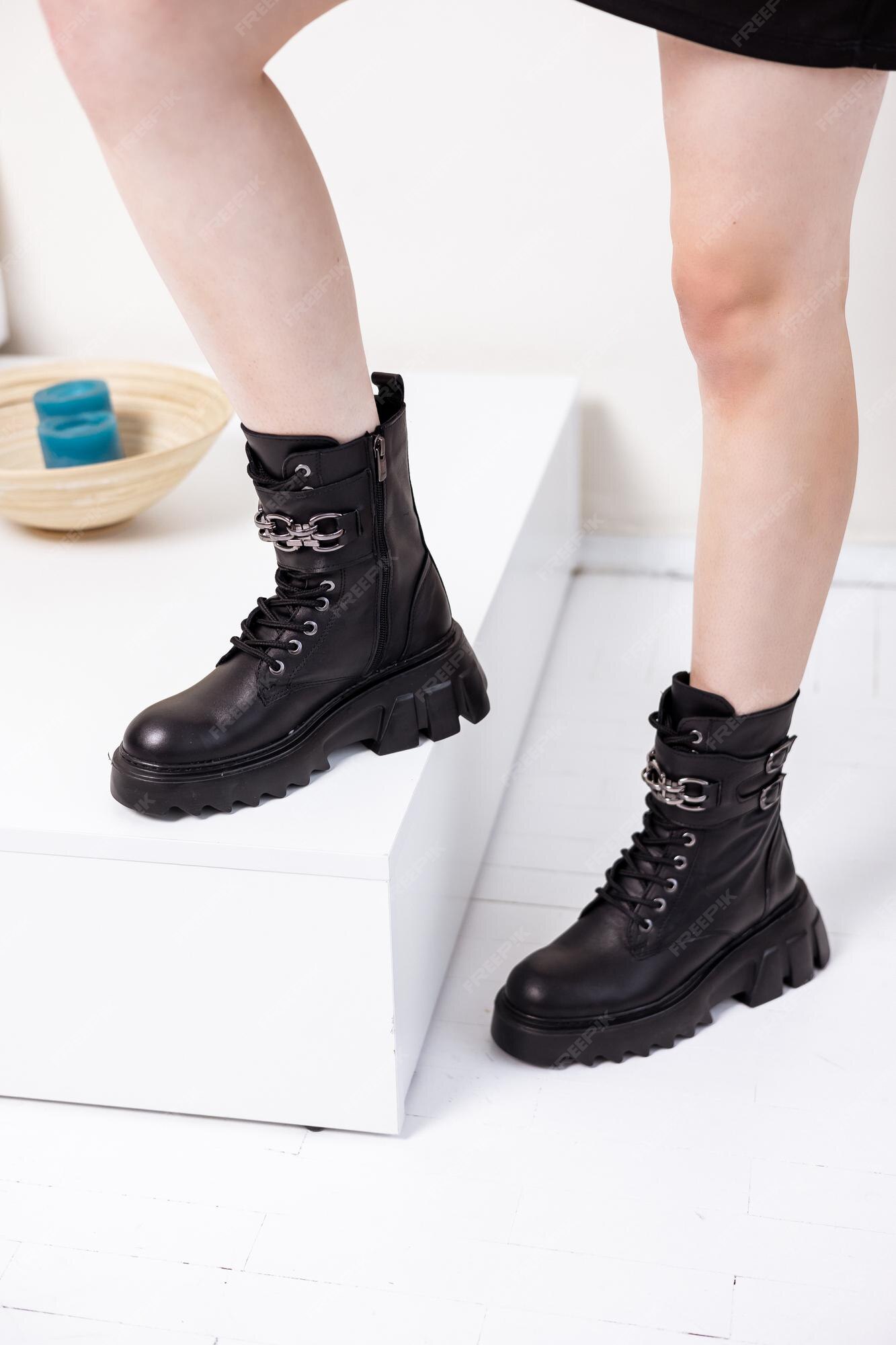 Hermosas piernas femeninas con botas negras de moda en el fondo del botas de cuero con estilo para mujer. | Foto Premium