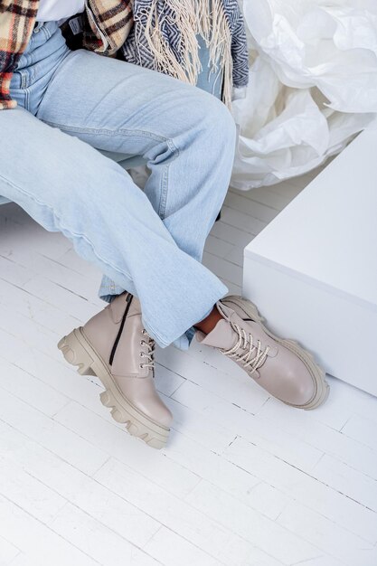 Hermosas piernas femeninas en jeans y botas de cuero. Piernas femeninas en botas de moda