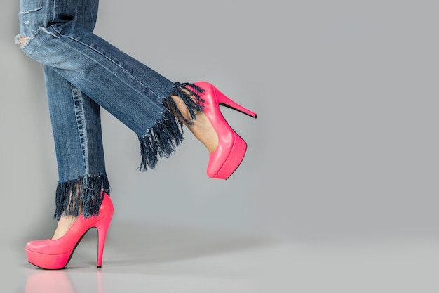 Foto hermosas piernas de mujer con tacones altos y jeans