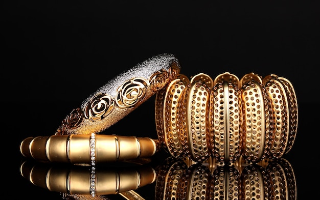 Hermosas pulseras doradas aisladas sobre un fondo negro
