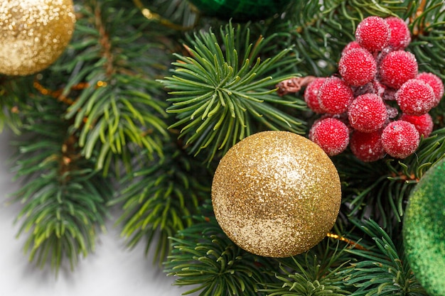 hermosas ramas de un árbol de Navidad con conos y juguetes en un primer plano de fondo de madera blanca