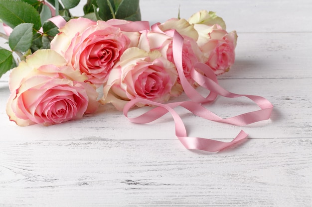 Hermosas rosas rosadas lbouquet acostado en una mesa de madera