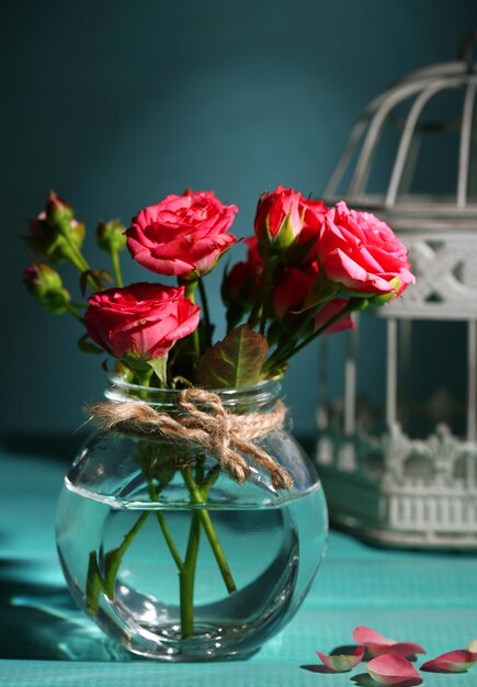 Hermosas rosas rosadas pequeñas, sobre fondo azul.