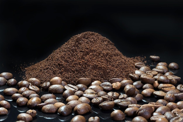 Hermosas semillas de café de cerca en un café molido de fondo negro